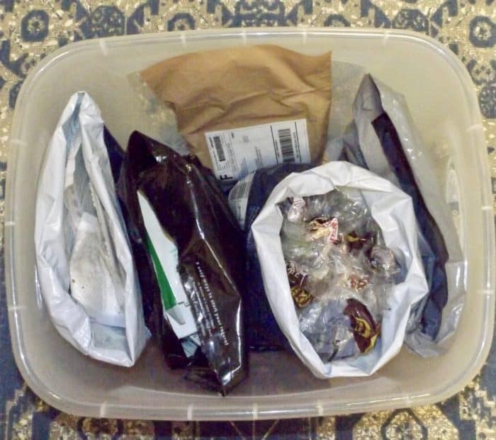 A plastic tub with plastic mailers full of stuff to be recycled through TerraCycle is pictured